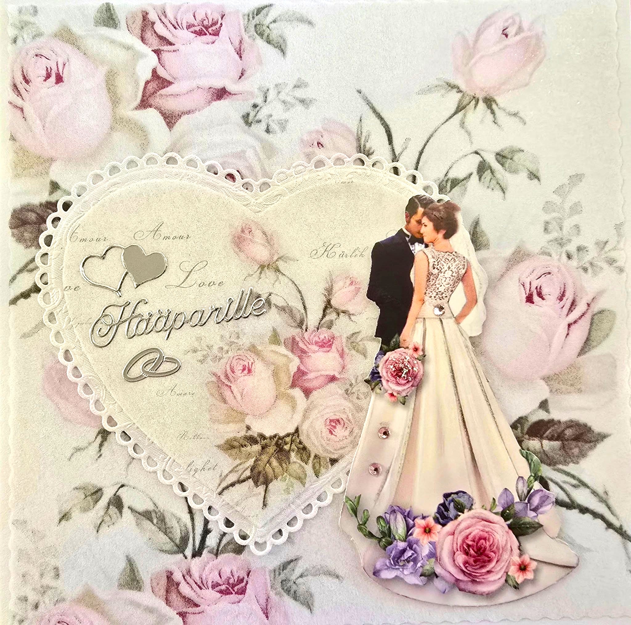 Käsintehty hääkortti, jossa on kukkakuvioinen tausta, sydänkehys ja hääpari. Kortissa lukee “Hääparille”, ja sitä koristavat vaaleanpunaiset ruusut ja sormussymboli.