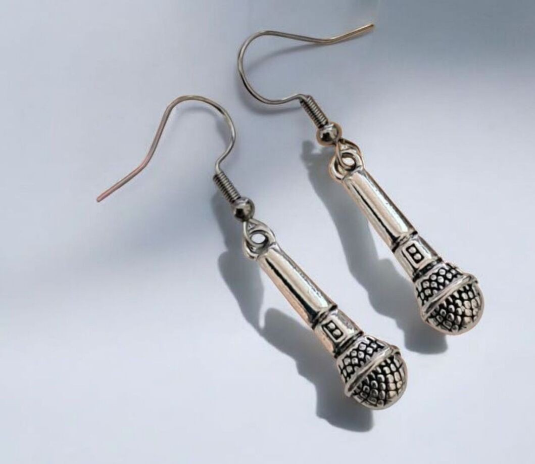 Mikrofoni-aiheiset hopeansävyiset korvakorut, jotka symboloivat laulua, esiintymistä ja rakkautta musiikkiin.