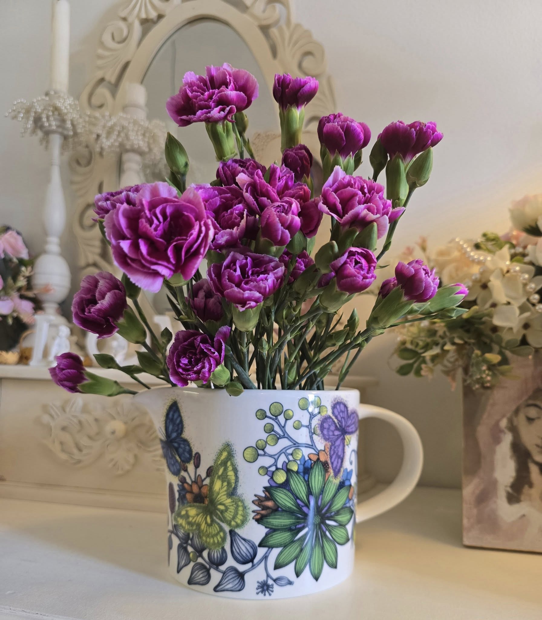 Violetit neilikat Arabian Neitoperhokannussa korupajan työpöydällä inspiraation lähteenä