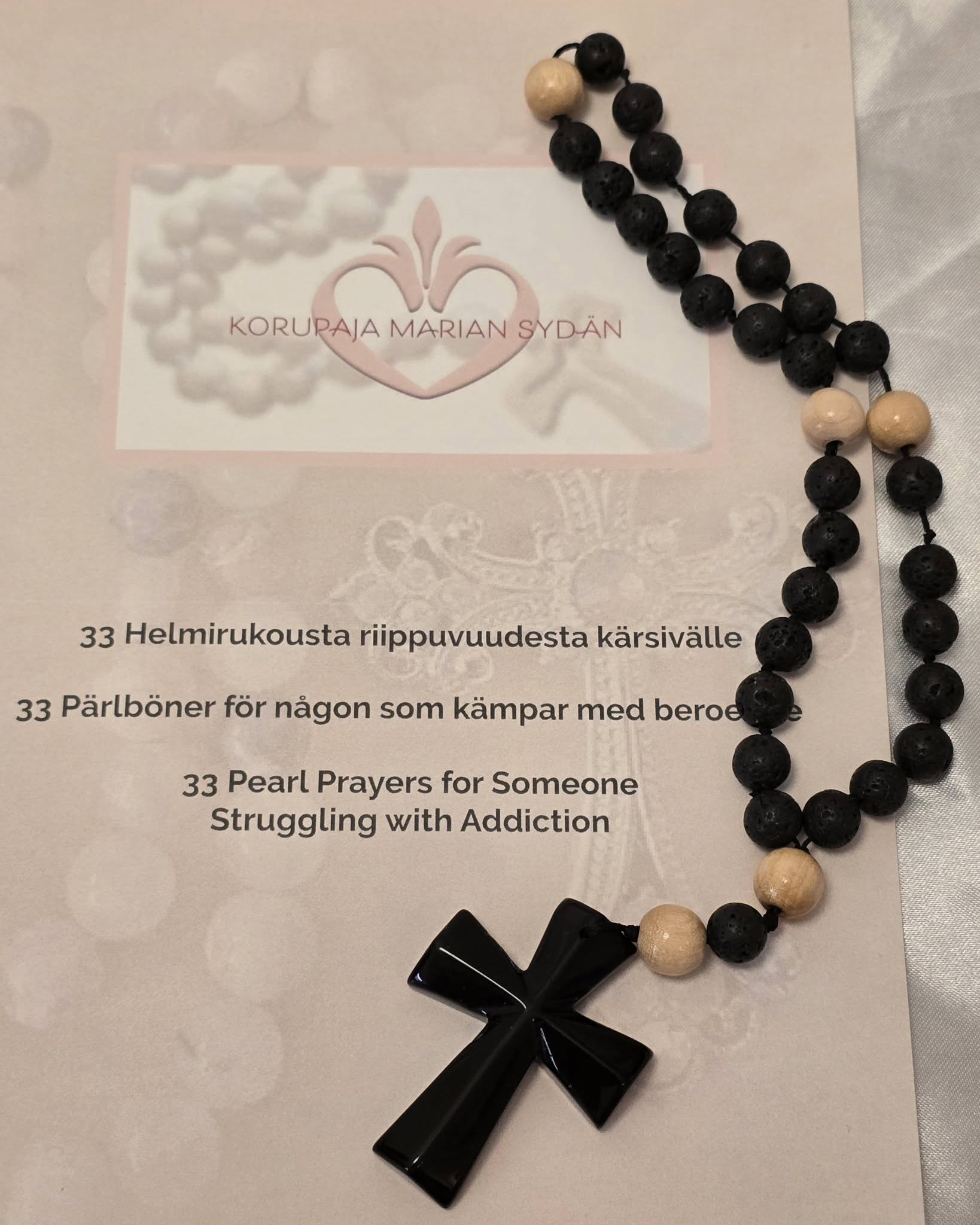 Kivihelmistä tehty luterilainen rukousnauha ja Korupaja Marian sydämen vihkonen 33 helmirukousta riippuvuudesta kärsivälle suomeksi, ruotsiksi ja englanniksi.
