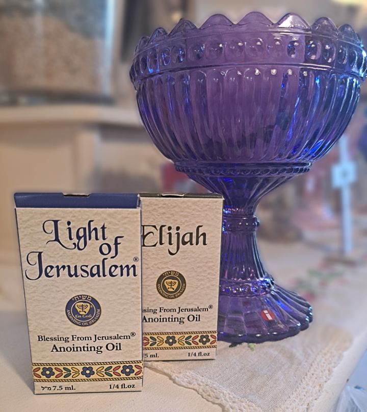 Israelilaiset rukousöljyt ja violetti jalallinen malja asetettuna pöydälle kodin rukoushetkeä varten.