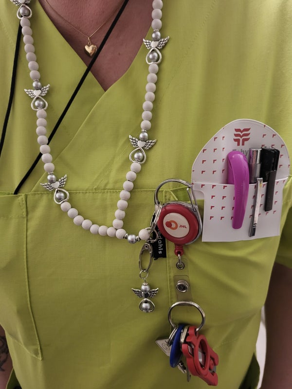 Valkoinen enkeliavainnauha hoitajalla yll&auml;